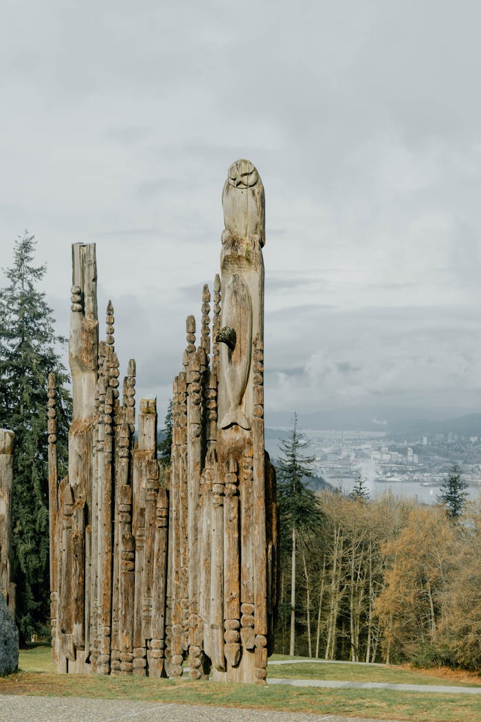Majestic wooden totem poles in a serene park setting in Burnaby, BC.