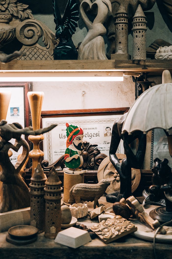 Eclectic display of vintage wooden sculptures and artifacts in a cozy indoor setting.
