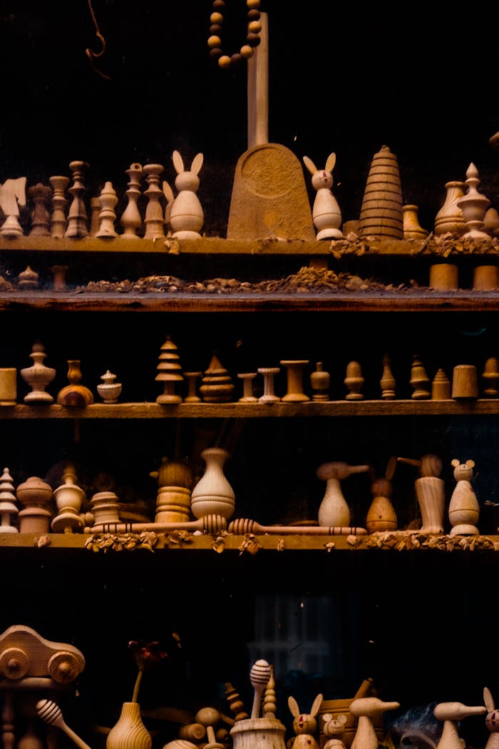A collection of assorted wood carved figurines arranged on dark shelves, perfect for wallpaper or artistic use.